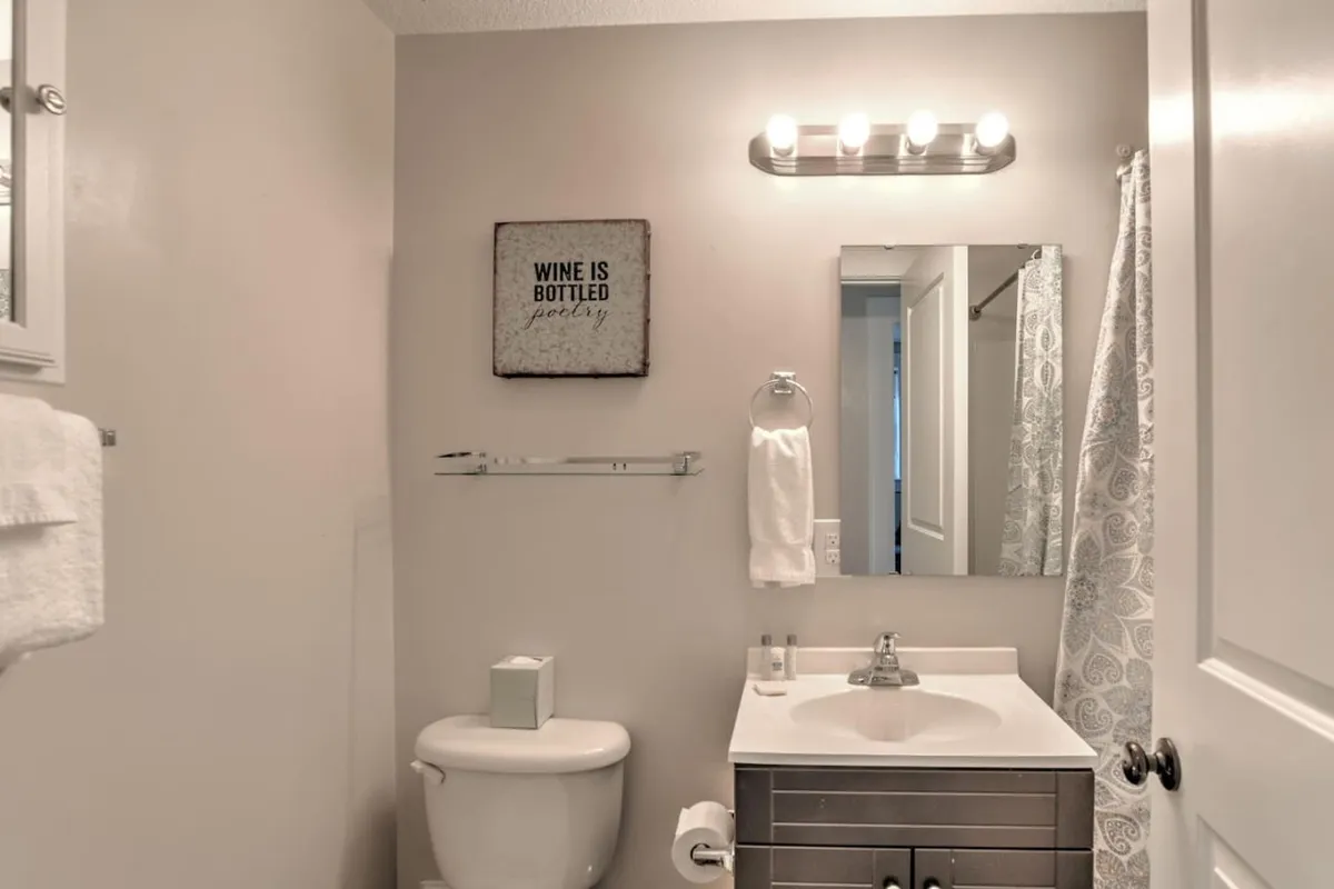 A recently renovated bathroom featuring a modern sink with a sleek faucet, a large mirror, framed wall art, and a towel rack. The space is bright, clean, and inviting, with subtle decor touches that add warmth and personality.